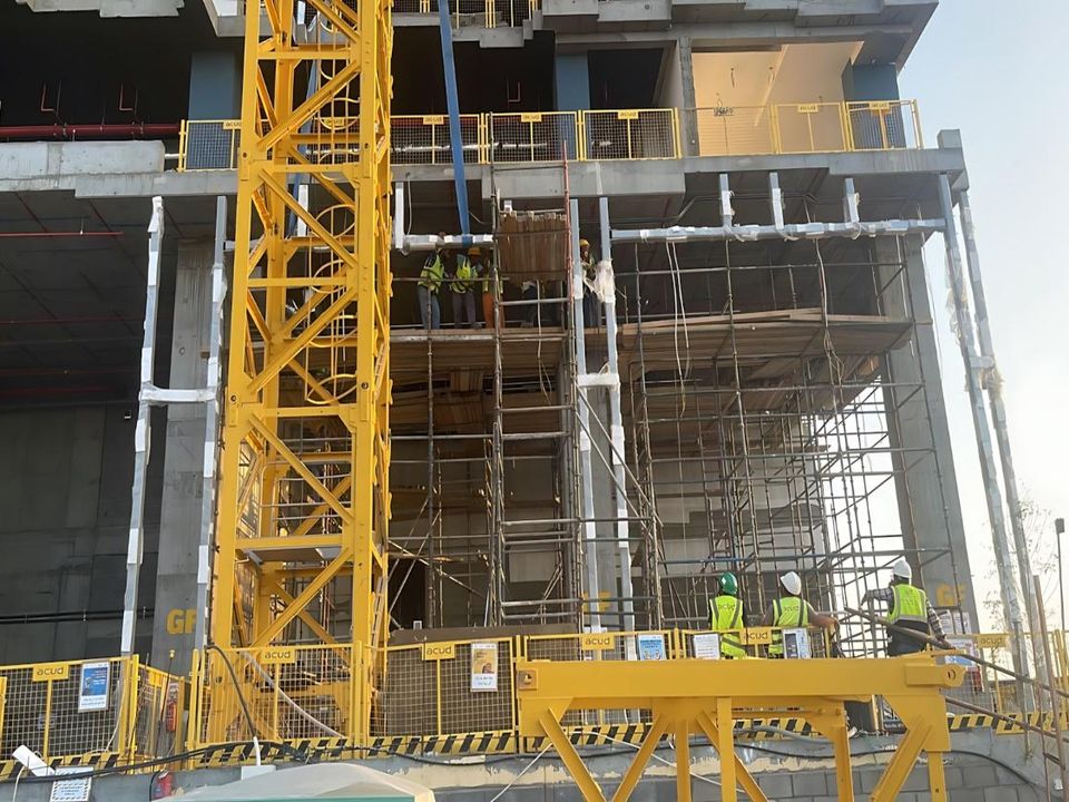 Pre-cast podium steel frame under construction with tower crane